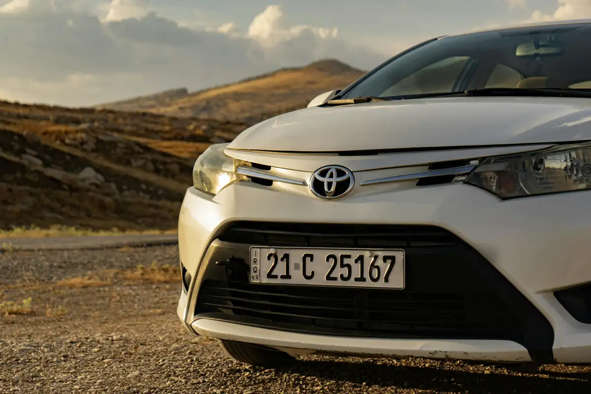 A white toyota car is shown outdoors.